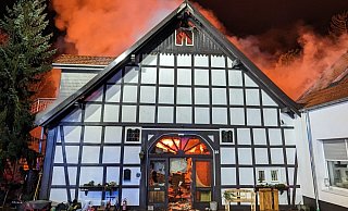 Im Inneren ist es, wie durch die gläserne Eingangstür sichtbar, feuerrot. Vor dem Haus parken noch Bobbycars der Tagespflege. - Feuerwehr Bad Oeynhausen Im Inneren ist es, wie durch die gläserne Eingangstür sichtbar, feuerrot. Vor dem Haus parken noch Bobbycars der Tagespflege. - Feuerwehr Bad Oeynhausen