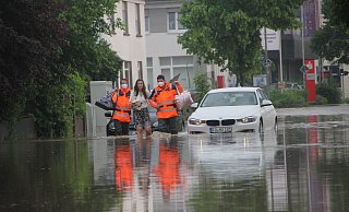 Feuerwehrmänner begleiten im Juni vergangenen Jahres eine Frau durch das Hochwasser an der Engerstraße. - Florian Weyand Feuerwehrmänner begleiten im Juni vergangenen Jahres eine Frau durch das Hochwasser an der Engerstraße. - Florian Weyand