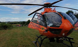 Der Rettungshubschrauber wartet darauf, den 44-Jährigen in eine Klinik fliegen zu können. Im Hintergrund ist das Unfallgeschehen zu sehen. - Burkhard Battran Der Rettungshubschrauber wartet darauf, den 44-Jährigen in eine Klinik fliegen zu können. Im Hintergrund ist das Unfallgeschehen zu sehen. - Burkhard Battran