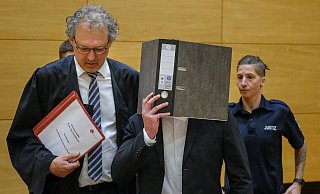 Der Angeklagte verdeckt sein Gesicht mit einem Ordner. Er soll seine Kollegin bei einer Party erstochen haben. - Andreas Zobe (Archiv) Der Angeklagte verdeckt sein Gesicht mit einem Ordner. Er soll seine Kollegin bei einer Party erstochen haben. - Andreas Zobe (Archiv)