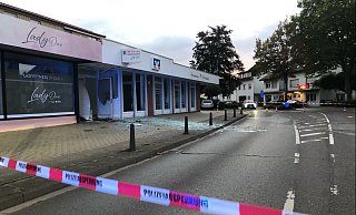 Glasscherben und Trümmerteile liegen vor der Filiale auf dem Gehweg verteilt. - Polizei Minden-Lübbecke Glasscherben und Trümmerteile liegen vor der Filiale auf dem Gehweg verteilt. - Polizei Minden-Lübbecke