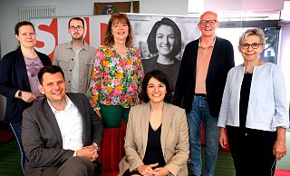 Gruppenbild mit doppelter Kandidatin: Sitzend mit Thorsten Klute und Elvan Korkmaz-Emre; dahinter (v. l.), Ann Katrin Brambrink, Matthis Haverland, Anne Rodenbrock-Wesselmann, (die Kandidatin auf Leinwand), Wolfgang Bölling und Marion Weike. - Andreas Frücht Gruppenbild mit doppelter Kandidatin: Sitzend mit Thorsten Klute und Elvan Korkmaz-Emre; dahinter (v. l.), Ann Katrin Brambrink, Matthis Haverland, Anne Rodenbrock-Wesselmann, (die Kandidatin auf Leinwand), Wolfgang Bölling und Marion Weike. - Andreas Frücht