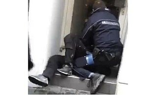 Dieser Screenshot zeigt, wie eine Ordnungskraft die Frau in einem Hauseingang liegend festhält. - Screenshot NW Dieser Screenshot zeigt, wie eine Ordnungskraft die Frau in einem Hauseingang liegend festhält. - Screenshot NW