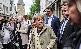 Die ehemalige Bundeskanzlerin Angela Merkel (M, CDU) und Hendrik Wüst (hinten, CDU), Ministerpräsident von Nordrhein-Westfalen bei ihrem Besuch in Bad Münstereifel. - dpa Die ehemalige Bundeskanzlerin Angela Merkel (M, CDU) und Hendrik Wüst (hinten, CDU), Ministerpräsident von Nordrhein-Westfalen bei ihrem Besuch in Bad Münstereifel. - dpa