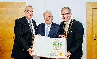 Gildemeister Johannes Beverungen (v. l.), Joachim Gauck und Bürgermeister Michael Dreier zeigen die Seite im Goldenen Buch mit dem Eintrag des früheren Bundespräsidenten. - Besim Mazhiqi Gildemeister Johannes Beverungen (v. l.), Joachim Gauck und Bürgermeister Michael Dreier zeigen die Seite im Goldenen Buch mit dem Eintrag des früheren Bundespräsidenten. - Besim Mazhiqi