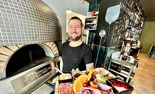 Benjamin „Benni“ Demir präsentiert eine Frühstücksplatte. Neben ihm ist der italienische Pizzaofen zu sehen. - Jens Reddeker Benjamin „Benni“ Demir präsentiert eine Frühstücksplatte. Neben ihm ist der italienische Pizzaofen zu sehen. - Jens Reddeker