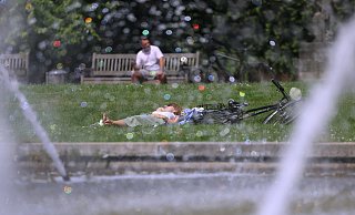 Eine Frau genießt eine Pause im Park. - David Young Eine Frau genießt eine Pause im Park. - David Young