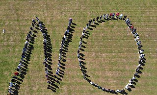 Rund 200 Schüllerinnen und Schüler bilden das "No", das von einer Drohne fotografiert wurde. - BBG Rund 200 Schüllerinnen und Schüler bilden das "No", das von einer Drohne fotografiert wurde. - BBG