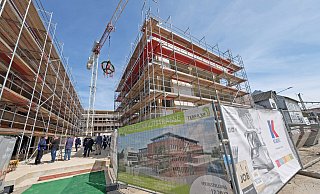 Über der Plaza inmitten der drei Gebäuderiegel schwebt der Richtkranz am Haken des Krans. In das reche Gebäude zieht das Funkhaus von Radio Westfalica und Radio Herford ein. - Thorsten Gödecker Über der Plaza inmitten der drei Gebäuderiegel schwebt der Richtkranz am Haken des Krans. In das reche Gebäude zieht das Funkhaus von Radio Westfalica und Radio Herford ein. - Thorsten Gödecker