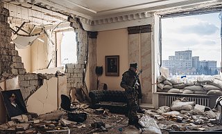 Ein ukrainischer Soldat vor dem zerstörten Regierungsgebäude in Charkiw. - picture alliance / AA Ein ukrainischer Soldat vor dem zerstörten Regierungsgebäude in Charkiw. - picture alliance / AA