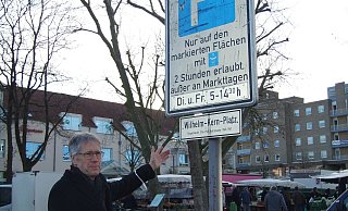Der inzwischen in den Ruhestnd getretene ehemalige Bezirkseamte Ulrich Riebe blickt auf das Schild am Eingang zum Wilhelm-Kern-Platz. An Markttagen hat er sich hier regelmäßig blicken lassen. - Karsten Schulz Der inzwischen in den Ruhestnd getretene ehemalige Bezirkseamte Ulrich Riebe blickt auf das Schild am Eingang zum Wilhelm-Kern-Platz. An Markttagen hat er sich hier regelmäßig blicken lassen. - Karsten Schulz