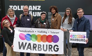 Judith Schlinker (Cineplex; v. l.), Anke Schekahn (Buntes Warburg), Wilm Pollmann (Warburger Hanse), Kathrin Helg (Buntes Warburg), Corinna Wieczorek (Sekundarschule), Selina Knipping (Warburger Hanse) und Bürgermeister Tobias Scherf mit dem neuen Logo. - Buntes Warburg Judith Schlinker (Cineplex; v. l.), Anke Schekahn (Buntes Warburg), Wilm Pollmann (Warburger Hanse), Kathrin Helg (Buntes Warburg), Corinna Wieczorek (Sekundarschule), Selina Knipping (Warburger Hanse) und Bürgermeister Tobias Scherf mit dem neuen Logo. - Buntes Warburg