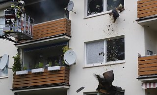 Die Feuerwehrleute werfen glimmende Gegenstände aus dem von Rauch ganz schwarzen Wohnzimmer. - Charlotte Mahncke Die Feuerwehrleute werfen glimmende Gegenstände aus dem von Rauch ganz schwarzen Wohnzimmer. - Charlotte Mahncke