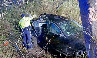 Nach dem Anprall an den Baum landete der schwer beschädigte BMW unterhalb der Dubelohstraße im Dickicht. Ein Polizeibeamter sichert Spuren. - Ralph Meyer Nach dem Anprall an den Baum landete der schwer beschädigte BMW unterhalb der Dubelohstraße im Dickicht. Ein Polizeibeamter sichert Spuren. - Ralph Meyer