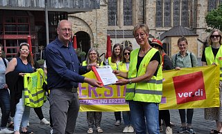 Petra Meyer (Verdi) überreicht Roger Voigtländer (SPD) die Liste mit den 1.500 gesammelten Unterschriften für bessere Arbeitsbedingungen. - Simon Schulz Petra Meyer (Verdi) überreicht Roger Voigtländer (SPD) die Liste mit den 1.500 gesammelten Unterschriften für bessere Arbeitsbedingungen. - Simon Schulz