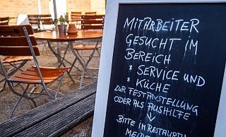 Auf einer Tafel vor einem Restaurant wird nach Mitarbeitern für den Service- und Küchenbereich gesucht. - picture alliance / Jens Büttner Auf einer Tafel vor einem Restaurant wird nach Mitarbeitern für den Service- und Küchenbereich gesucht. - picture alliance / Jens Büttner