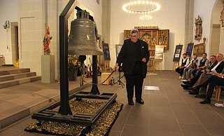 Monsignore Georg Austen, Generalsekretär des Bonifatiuswerkes, läutet die #PeaceBell zur Eröffnung der Ausstellung in der Gaukirche am Freitagabend. Am kommenden Mittwoch ist der Künstler Michael Patrick Kelly bei einem internationalen Friedensgebet im Paderborner Dom selbst zu Gast. Foto: Bonifatiuswerk/Matthias Band - Bonifatiuswerk/Matthias Band Monsignore Georg Austen, Generalsekretär des Bonifatiuswerkes, läutet die #PeaceBell zur Eröffnung der Ausstellung in der Gaukirche am Freitagabend. Am kommenden Mittwoch ist der Künstler Michael Patrick Kelly bei einem internationalen Friedensgebet im Paderborner Dom selbst zu Gast. Foto: Bonifatiuswerk/Matthias Band - Bonifatiuswerk/Matthias Band