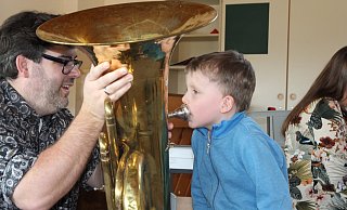 Am Tag der offenen Tür des Musikschulverbandes Espelkamp, Rahden, Stemwede konnten die Besucher alle Instrumente ausprobieren. Leiter Christian Wöbking hält die große Zugposaune für Josia, der kräftig hinein bläst. - Klaus Frensing Am Tag der offenen Tür des Musikschulverbandes Espelkamp, Rahden, Stemwede konnten die Besucher alle Instrumente ausprobieren. Leiter Christian Wöbking hält die große Zugposaune für Josia, der kräftig hinein bläst. - Klaus Frensing