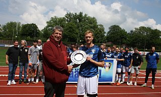Übergabe der Meisterschale: Staffelleiter Kai Rieke (vorne .l.) gratuliert Herfords Kapitän Nico Bartling, dahinter haben sich die Mannschaft und die Verantwortlichen des SCH versammelt. - Thomas Vogelsang Übergabe der Meisterschale: Staffelleiter Kai Rieke (vorne .l.) gratuliert Herfords Kapitän Nico Bartling, dahinter haben sich die Mannschaft und die Verantwortlichen des SCH versammelt. - Thomas Vogelsang