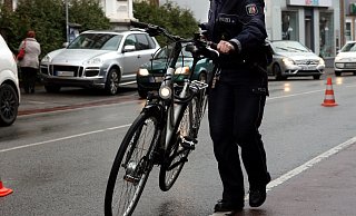 Eine Polizistin schiebt ein Fahrrad zum Streifenwagen. - Symbolfoto: Jens Reichenbach Eine Polizistin schiebt ein Fahrrad zum Streifenwagen. - Symbolfoto: Jens Reichenbach