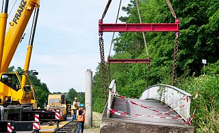 Am 25. Juni wurde die 110 Tonnen schwere Brücke von zwei Kränen neben der Fahrbahn der B1 abgelegt. - Ralph Meyer Am 25. Juni wurde die 110 Tonnen schwere Brücke von zwei Kränen neben der Fahrbahn der B1 abgelegt. - Ralph Meyer