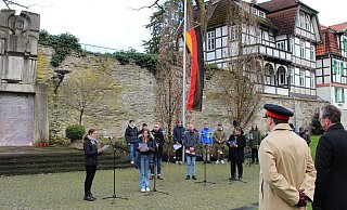 Bürgermeister Michael Dreier (2. v. r.) mit Colonel Mike Foster-Brown (3. v. r.) und Oberstleutnant Marco Maulbecker (r.) sowie Anna Schmidtmann (am Mikrofon l.) und Isolde Modlmayr (r.) am Mahnmal. - Pauline Maus Bürgermeister Michael Dreier (2. v. r.) mit Colonel Mike Foster-Brown (3. v. r.) und Oberstleutnant Marco Maulbecker (r.) sowie Anna Schmidtmann (am Mikrofon l.) und Isolde Modlmayr (r.) am Mahnmal. - Pauline Maus