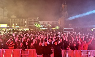 Das Organisationsteam (v. l.): Veranstaltungsverantwortlicher Tim Burrows, Henning Matthes, erster Beigeordneter der Stadt Gütersloh, und Michael Deppe, stellv. Leiter des Fachbereichs Kultur, vor der feiernden Menge. - Danielle Dörsing Das Organisationsteam (v. l.): Veranstaltungsverantwortlicher Tim Burrows, Henning Matthes, erster Beigeordneter der Stadt Gütersloh, und Michael Deppe, stellv. Leiter des Fachbereichs Kultur, vor der feiernden Menge. - Danielle Dörsing
