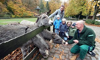 Cheftierpfleger Markus Hinker füttert und die Kinder Ole (v.l.), Leon und Jacob schauen mit ihren Müttern Maria (stehend) und Katharina zu. - Wolfgang Rudolf Cheftierpfleger Markus Hinker füttert und die Kinder Ole (v.l.), Leon und Jacob schauen mit ihren Müttern Maria (stehend) und Katharina zu. - Wolfgang Rudolf