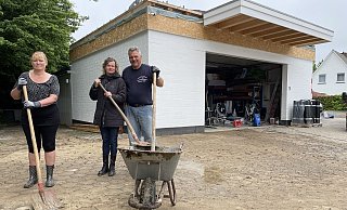 Susanne Konrad (v.l.), Anke und Christian Kirsch versuchen ihren Hof in Hiddenhausen vom Schlamm zu befreien. - Benedikt Riemer Susanne Konrad (v.l.), Anke und Christian Kirsch versuchen ihren Hof in Hiddenhausen vom Schlamm zu befreien. - Benedikt Riemer