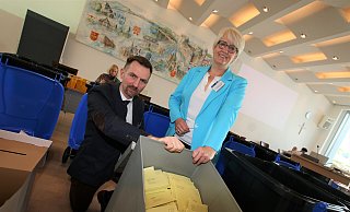 Im großen Sitzungssaal des Kreishauses Paderborn zeigen Christopher Schüngel, Leiter des Kreistagsbüros, und Annette Mühlenhoff, Vorsitzende des Wahlvorstands, eine Urne mit Unterlagen zur Weiterverarbeitung. Hierbei handelt es sich um Stimmen aus Bad Wünnenberg. - Rajkumar Mukherjee Im großen Sitzungssaal des Kreishauses Paderborn zeigen Christopher Schüngel, Leiter des Kreistagsbüros, und Annette Mühlenhoff, Vorsitzende des Wahlvorstands, eine Urne mit Unterlagen zur Weiterverarbeitung. Hierbei handelt es sich um Stimmen aus Bad Wünnenberg. - Rajkumar Mukherjee