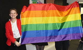 Johanna und Maxim halten die Regenbogenflagge. Maxim wollte unerkannt bleiben. Auch Luisa und ihre Freundin, die sie begeleitet hatte, bleiben hinter der Flagge. - Anastasia von Fugler Johanna und Maxim halten die Regenbogenflagge. Maxim wollte unerkannt bleiben. Auch Luisa und ihre Freundin, die sie begeleitet hatte, bleiben hinter der Flagge. - Anastasia von Fugler
