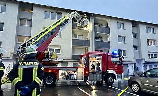 Bürener Feuerwehrleute kontrollieren von der Drehleiter aus die Traufschalung des Wohnblocks und löschen vereinzelte Glutnester oberhalb des Balkons im 3. Obergeschoss ab. - Ralph Meyer Bürener Feuerwehrleute kontrollieren von der Drehleiter aus die Traufschalung des Wohnblocks und löschen vereinzelte Glutnester oberhalb des Balkons im 3. Obergeschoss ab. - Ralph Meyer