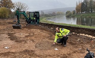 Ralf Mahytka, Archäologe bei der Landesgartenschau in Höxter, sichert die Spuren urzeitlicher Besiedlung am Weserufer, die bei den Bauarbeiten aufgetaucht waren. Bei den dunklen Verfärbungen handelt es sich um Pfostengruben und Lehmentnahmegruben. - LGS 2023 Höxter/Maike Koegel Ralf Mahytka, Archäologe bei der Landesgartenschau in Höxter, sichert die Spuren urzeitlicher Besiedlung am Weserufer, die bei den Bauarbeiten aufgetaucht waren. Bei den dunklen Verfärbungen handelt es sich um Pfostengruben und Lehmentnahmegruben. - LGS 2023 Höxter/Maike Koegel