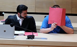 Der Angeklagte Ilya T. versteckt sein Gesicht hinter einem Aktendeckel. - Wolfgang Rudolf Der Angeklagte Ilya T. versteckt sein Gesicht hinter einem Aktendeckel. - Wolfgang Rudolf