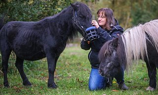 Drei, die sich mögen: das schwarze Shetlandpony Ätna, hier mit seinem Spezial-Maulkorb, Natalie Böger und Minihengst Timmy. - Sarah Jonek Drei, die sich mögen: das schwarze Shetlandpony Ätna, hier mit seinem Spezial-Maulkorb, Natalie Böger und Minihengst Timmy. - Sarah Jonek