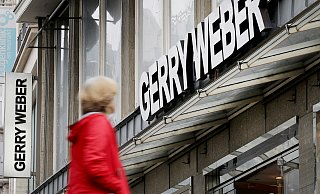 Eine Passantin geht an einer Filiale des Modeherstellers Gerry Weber vorbei. Der Konzern hat der Kette eine erneute Schrumpfkur verordnet. - dpa Eine Passantin geht an einer Filiale des Modeherstellers Gerry Weber vorbei. Der Konzern hat der Kette eine erneute Schrumpfkur verordnet. - dpa