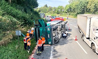 Die Feuerwehrmänner haben den auslaufenden Treibstoff gebunden und Polizisten inspizieren das Fahrwerk des Sattelzugs. - LA Hillegossen Die Feuerwehrmänner haben den auslaufenden Treibstoff gebunden und Polizisten inspizieren das Fahrwerk des Sattelzugs. - LA Hillegossen