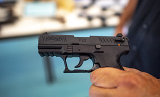 Ein Polizist zeigt eine Pistole der Marke Walther, Modell P22, die bei einer Hausdurchsuchung am Mittwoch sichergestellt wurde. - picture alliance Ein Polizist zeigt eine Pistole der Marke Walther, Modell P22, die bei einer Hausdurchsuchung am Mittwoch sichergestellt wurde. - picture alliance
