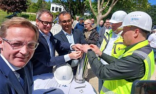 Staatssekretär Daniel Sieveke (v. l.) schaut genau hin, wie Stadtwerke-Chef Leander Sasse, Architekt Thomas Kalman, Albrecht Schaeffer, Projektleiter bei den Stadtwerken und Bäderleiter Thorsten Müller die Zeitkapsel füllen und verschließen. Nur für einen kurzen Moment lässt er sich ablenken. - Dieter Scholz Staatssekretär Daniel Sieveke (v. l.) schaut genau hin, wie Stadtwerke-Chef Leander Sasse, Architekt Thomas Kalman, Albrecht Schaeffer, Projektleiter bei den Stadtwerken und Bäderleiter Thorsten Müller die Zeitkapsel füllen und verschließen. Nur für einen kurzen Moment lässt er sich ablenken. - Dieter Scholz