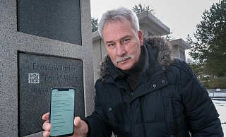 Detlef Wittig an der Urnenstele auf dem Altenhagener Friedhof. Hier soll sein Bruder Ernie die letzte Ruhe finden. Über einen QR-Code auf der Stele kommt man auf seine Wikipedia-Seite. - Foto: Andreas Zobe/NW Detlef Wittig an der Urnenstele auf dem Altenhagener Friedhof. Hier soll sein Bruder Ernie die letzte Ruhe finden. Über einen QR-Code auf der Stele kommt man auf seine Wikipedia-Seite. - Foto: Andreas Zobe/NW