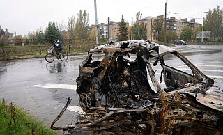 Ein Mann fährt in Bachmut mit seinem Fahrrad an einem Auto vorbei, das durch Beschuss zerstört wurde. - Efrem Lukatsky/AP/dpa Ein Mann fährt in Bachmut mit seinem Fahrrad an einem Auto vorbei, das durch Beschuss zerstört wurde. - Efrem Lukatsky/AP/dpa