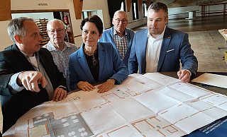 Der Blick nach vorn: Andre Volmary (v. l.), Vorsitzender der Daseburger Vereinsgemeinschaft, Landesministerin Silke Gorißen und Bezirksverwaltungsstellenleiter Thomas Klenke. Hermann-Josef Ewe von der Rentner AG und Günter Thill vom VdK schauen ihnen über die Schulter. Auf dem Tisch liegt der Bauplan. - Dieter Scholz Der Blick nach vorn: Andre Volmary (v. l.), Vorsitzender der Daseburger Vereinsgemeinschaft, Landesministerin Silke Gorißen und Bezirksverwaltungsstellenleiter Thomas Klenke. Hermann-Josef Ewe von der Rentner AG und Günter Thill vom VdK schauen ihnen über die Schulter. Auf dem Tisch liegt der Bauplan. - Dieter Scholz