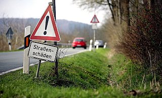 Im Streckenverlauf der L 876 weisen Schilder auf den Zustand der Straße hin. Die Fahrbahn weist etliche Spurrillen und Risse auf. Der Landesbetrieb Straßenbau stuft den Zustand als befriedigend ein. Ein Ausbau der Straße ist nicht in Sicht. - FOTO: TYLER LARKIN Im Streckenverlauf der L 876 weisen Schilder auf den Zustand der Straße hin. Die Fahrbahn weist etliche Spurrillen und Risse auf. Der Landesbetrieb Straßenbau stuft den Zustand als befriedigend ein. Ein Ausbau der Straße ist nicht in Sicht. - FOTO: TYLER LARKIN
