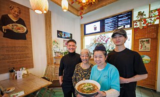 Anh Duy Nguyen (v. l.), Namenspatronin und Rezept-Erfinderin Gái Nguyen, Chefin Thi Phuong Mai Nguyen und Gia-Bao Qiu mit einer dampfenden Schüssel Phô-Suppe. - Oliver Krato Anh Duy Nguyen (v. l.), Namenspatronin und Rezept-Erfinderin Gái Nguyen, Chefin Thi Phuong Mai Nguyen und Gia-Bao Qiu mit einer dampfenden Schüssel Phô-Suppe. - Oliver Krato