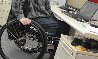 Ein Mann sitzt in einem Rollstuhl an seinem Arbeitsplatz am Schreibtisch. Inklusion ist ein w - dpa Ein Mann sitzt in einem Rollstuhl an seinem Arbeitsplatz am Schreibtisch. Inklusion ist ein w - dpa