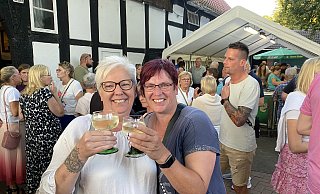 Die Schwestern Nicole Krüger (l.) und Martina Buchholz sind Stammgäste auf dem Rehmer Markt. Sie stoßen mit einem Weißwein darauf an, auch dieses Jahr wieder viele Bekannte rund ums Heimathaus zu treffen. - Nicole Sielermann Die Schwestern Nicole Krüger (l.) und Martina Buchholz sind Stammgäste auf dem Rehmer Markt. Sie stoßen mit einem Weißwein darauf an, auch dieses Jahr wieder viele Bekannte rund ums Heimathaus zu treffen. - Nicole Sielermann