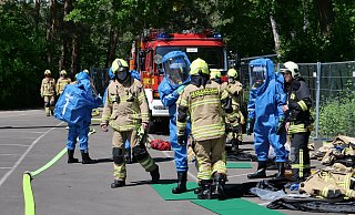 Vier Feuerwehrleute rüsten sich auf dem Parkplatz des Waldbades mit Chemieschutzanzügen aus. - Ralph Meyer Vier Feuerwehrleute rüsten sich auf dem Parkplatz des Waldbades mit Chemieschutzanzügen aus. - Ralph Meyer