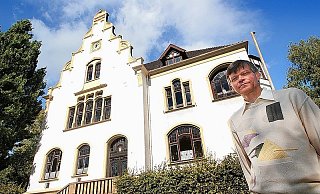 Ulrich Dittmar (großes Foto) vor seiner Musikschule. Das Innenleben der Uhr unter dem Dachgiebel nimmt einen gesamten Raum auf dem Dachboden ein. Zeitzeugen auf Bleiglas sind im kleinen Foto zu sehen. Wappen sowie die früheren Landgemeinden des Amts Ennigloh zieren die Scheiben im Konzertsaal. - FOTO: STEFFENS Ulrich Dittmar (großes Foto) vor seiner Musikschule. Das Innenleben der Uhr unter dem Dachgiebel nimmt einen gesamten Raum auf dem Dachboden ein. Zeitzeugen auf Bleiglas sind im kleinen Foto zu sehen. Wappen sowie die früheren Landgemeinden des Amts Ennigloh zieren die Scheiben im Konzertsaal. - FOTO: STEFFENS