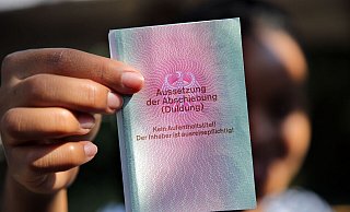 Eine junge Frau aus Afrika mit einem Ausweis für Flüchtlinge: «Aussetzung der Abschiebung (Duldung)». Darunter ist der Vermerk: «Kein Aufenthaltstitel!» - Wolfgang Kumm/dpa Eine junge Frau aus Afrika mit einem Ausweis für Flüchtlinge: «Aussetzung der Abschiebung (Duldung)». Darunter ist der Vermerk: «Kein Aufenthaltstitel!» - Wolfgang Kumm/dpa
