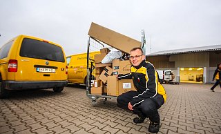 Hochgestapelt: Ansgar Peine zieht aus der erweiterten Pakethalle ein Rollgitter mit Paketen zum Lieferwagen. - David Schellenberg Hochgestapelt: Ansgar Peine zieht aus der erweiterten Pakethalle ein Rollgitter mit Paketen zum Lieferwagen. - David Schellenberg